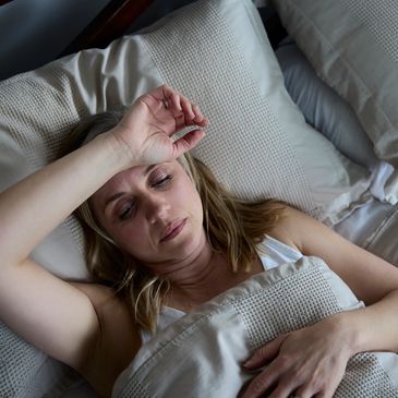 Tired solemn woman in bed feeling symptoms of chronic fatigue