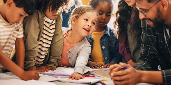 Children gathered around a table engaged in a lively learning activity.