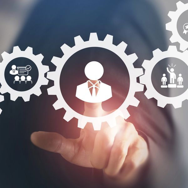 Businessman interacting with digital gears representing teamwork and management.