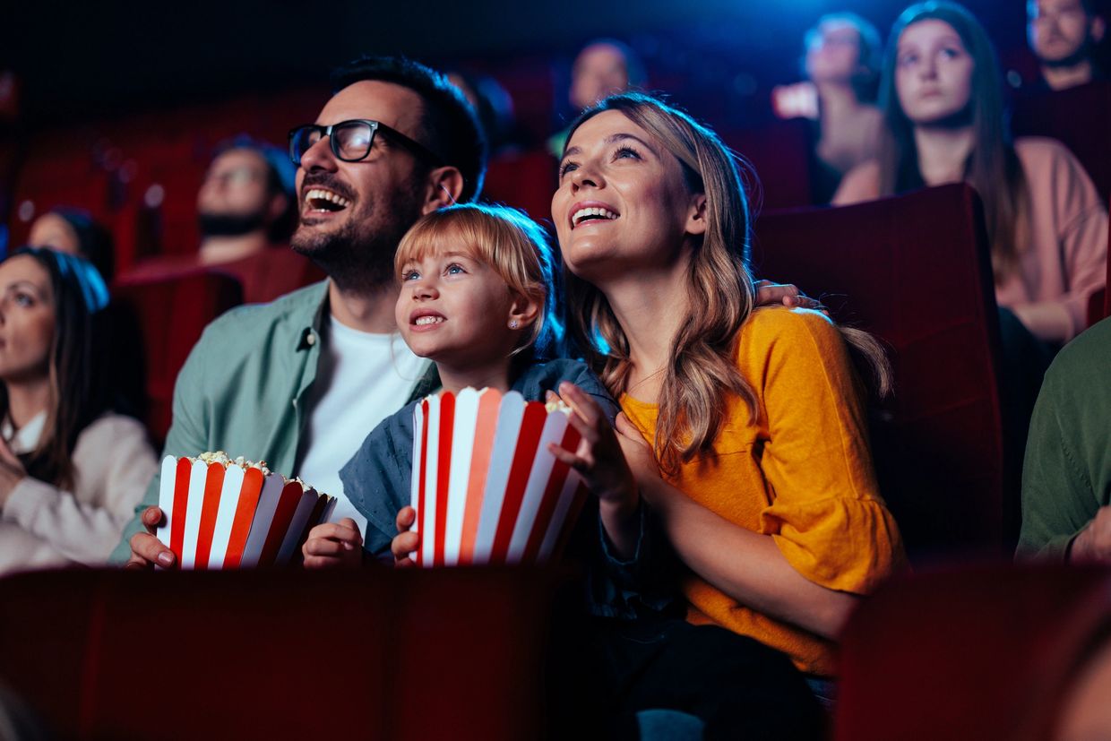 A family enjoying a movie together with popcorn in a theater.