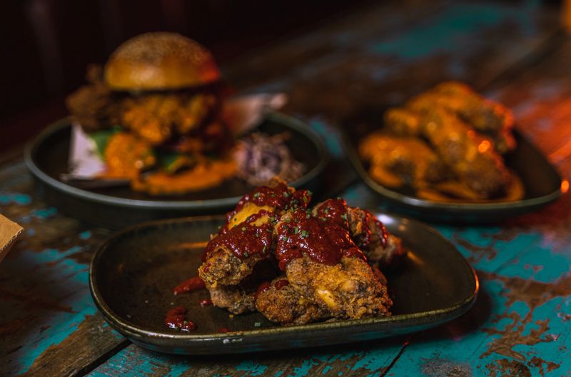 A closeup shot of chicken burgers and wings in dark grungy restaurant settings