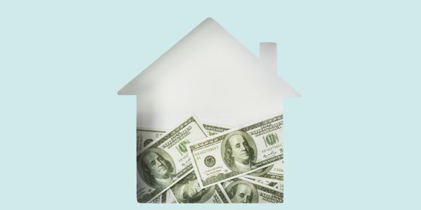 House-shaped cutout filled with hundred-dollar bills symbolizing home finance.