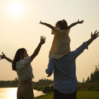 Familia disfrutando al atardecer junto al agua.