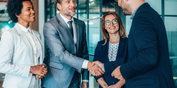 Business professionals shaking hands in an office setting.