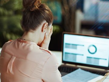 Frustrated woman working on a laptop.