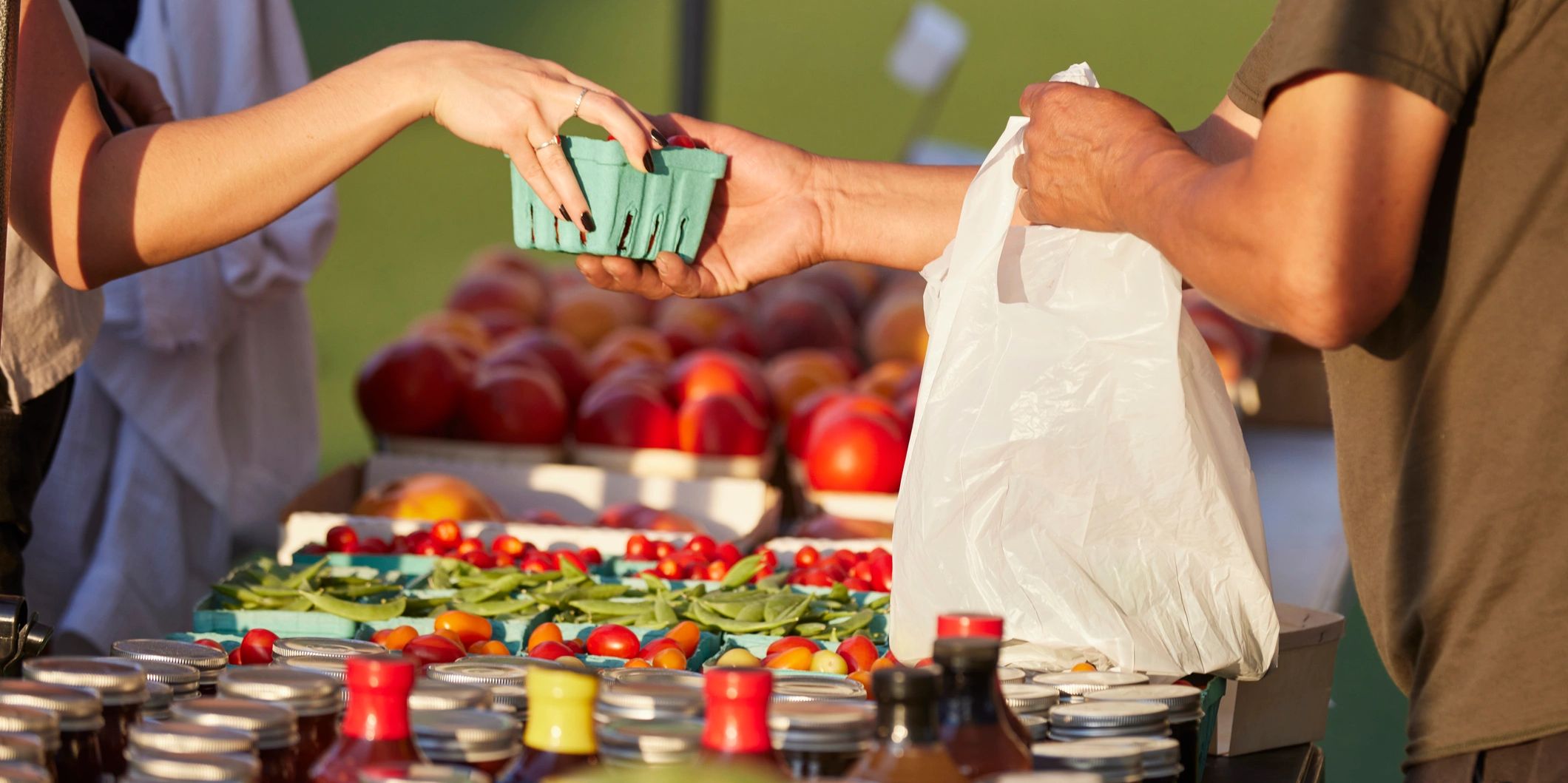 Exchanging fresh produce at a market stall.