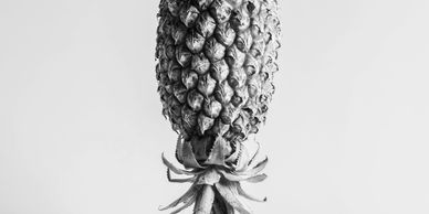 An upside-down pineapple against a pastel pink background.