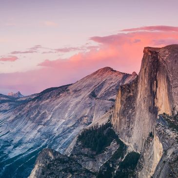 Half Dome at Yosemite National Park during sunset with vibrant pink and purple skies.