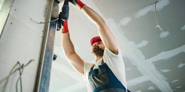 Iemand dat gyproc plafonds en wanden maakt.