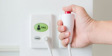 Hand pressing a hospital call button.