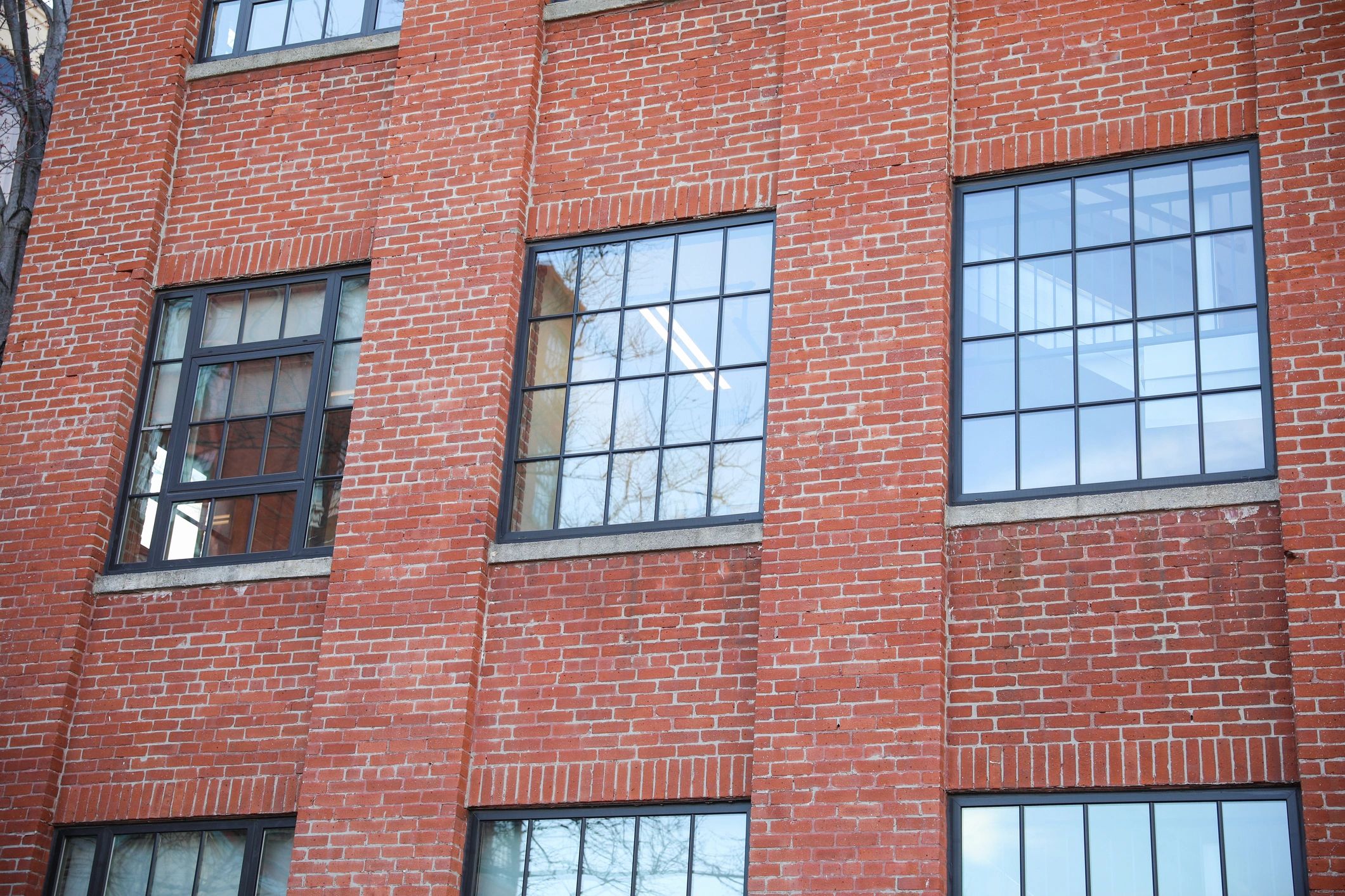 Modern black-framed windows on a red brick building.