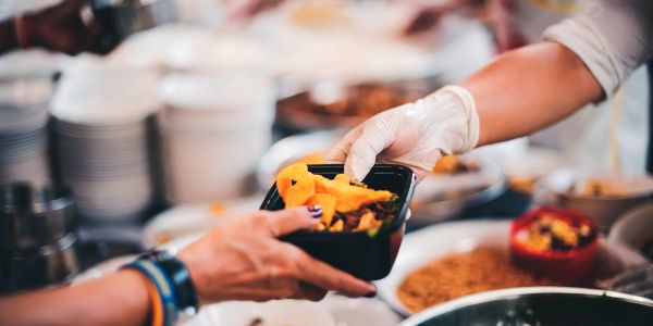 Person serving food to another person.