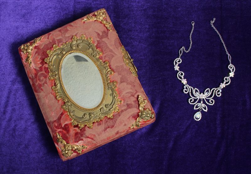 Crystal Rhinestone Jewelry on Antique Book With Purple Velvet Background