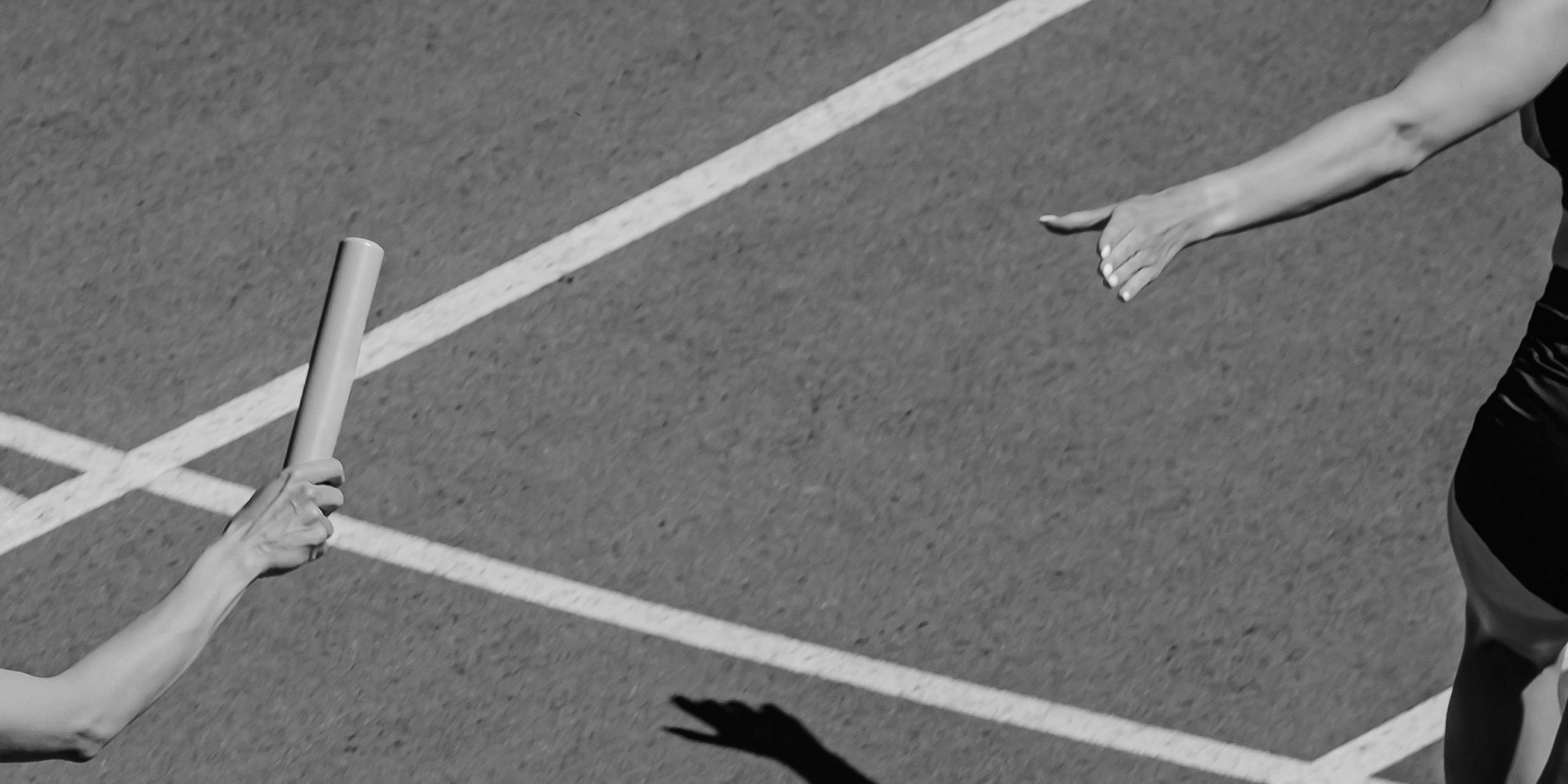 Image of a person running and passing a baton