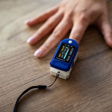 Pulse oximeter on a finger measuring oxygen levels.