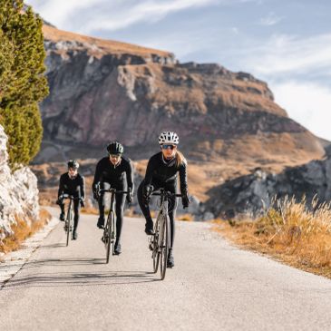 Three cyclists riding on a mountain road.