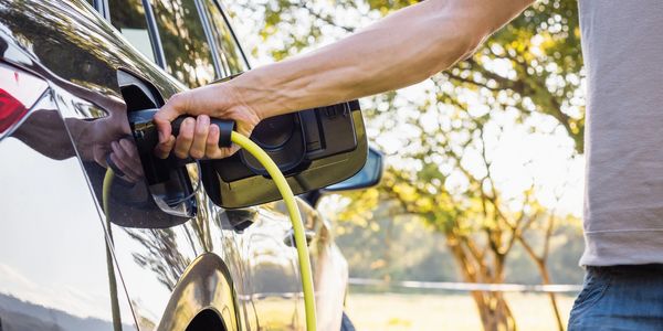 Man plugging electric car in