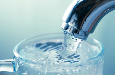 Water flowing from a faucet into a glass.