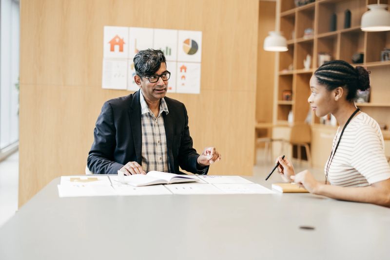 Businessman and woman in team collaboration looking at company graph, chart or analysis in the office