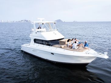 People relaxing on a white yacht in open water.