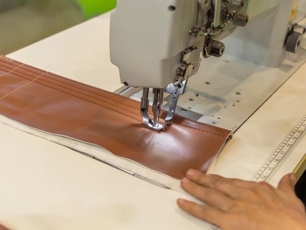 Someone sewing a hot spa cover on a machine.