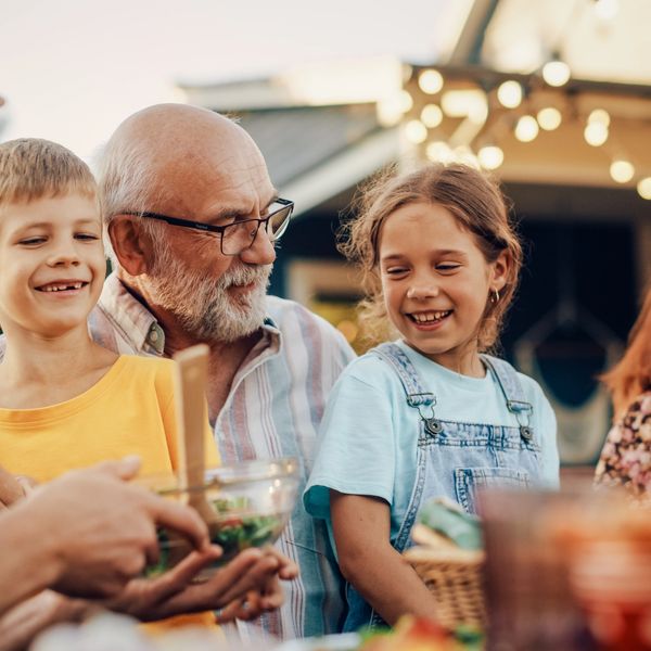 Family enjoying a joyful outdoor meal together in the evening.