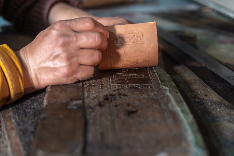 Hands of an artisan embossing in leather. High quality photo