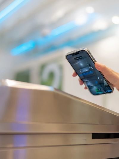 Person using smartphone to scan or access a device or terminal.