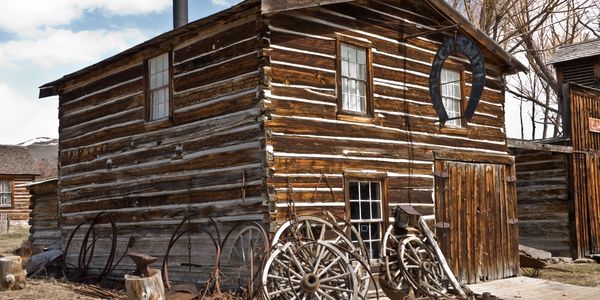 Old wooden barn with rustic wheels and horseshoe.