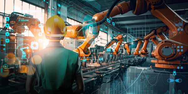 Engineer overseeing robotic arms in automated factory.