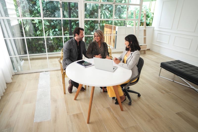 Real estate agent talking to a couple in a house
