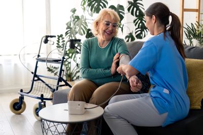 A home carer helping an elderly service user with tasks at her home.