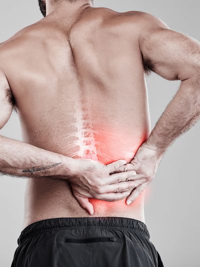 Man with lower back pain highlighted in red.