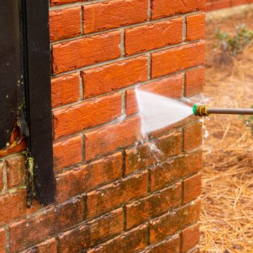 Pressure washing with soft washing treatment to brick