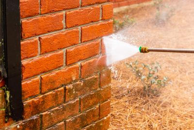 Spraying water on a brick wall.
