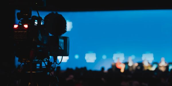 Professional video camera filming a panel discussion.