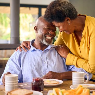 Happy elderly couple sharing a tender moment during breakfast.