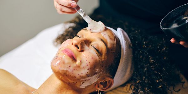 Woman receiving a facial mask treatment at a spa.
