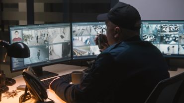 Security guard monitoring surveillance cameras.