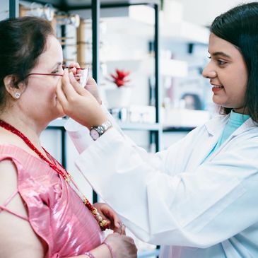 Woman undergoing eye examination with slit lamp at optometrist.