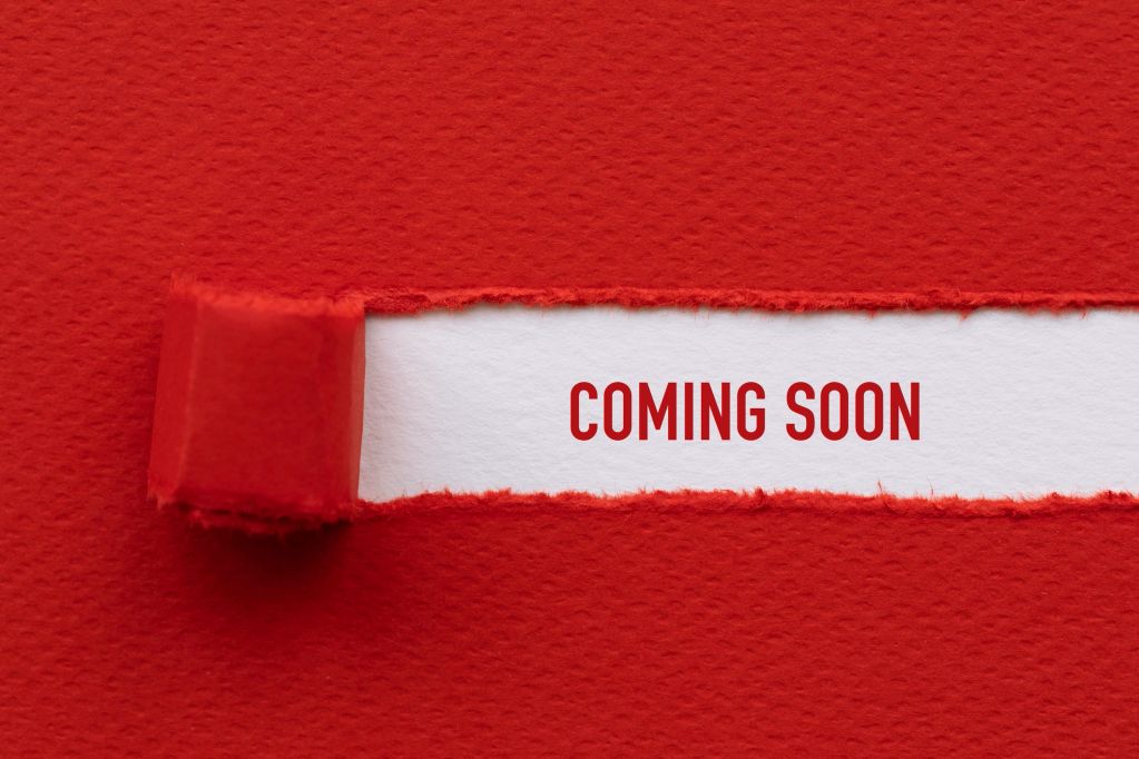 Red paper torn to reveal the words 'COMING SOON'.