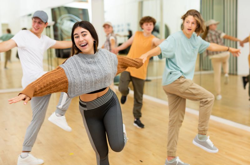 Energetic teenagers formed pairs and dancing swing in studio.