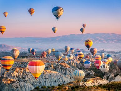 Globos aerostáticos sobre un paisaje rocoso al amanecer.