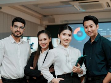 Four professionals posing confidently in an office.