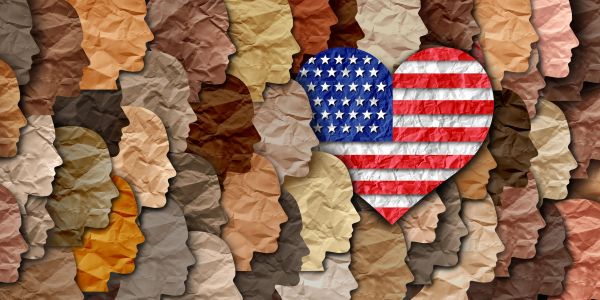 Diverse human faces surrounding a heart with the American flag.