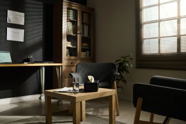 Cozy, softly lit room with modern furniture and a wooden table.