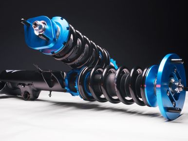 Blue shock absorber and strut assembly on bench before installation.