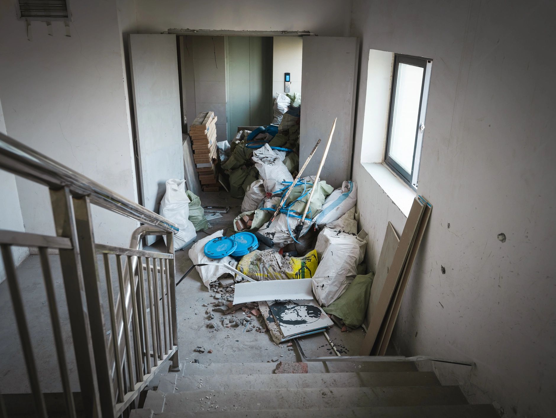 Cluttered stairway filled with construction materials and debris.