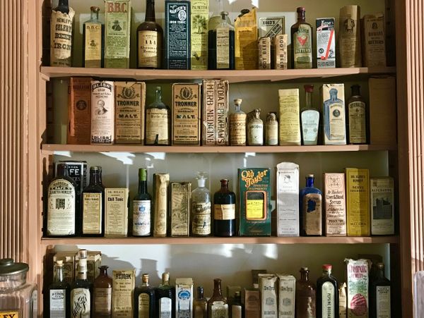 Shelves filled with vintage medicinal bottles and remedies from an old apothecary.