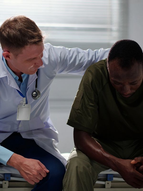 Doctor comforting a distressed patient in a clinical setting.
